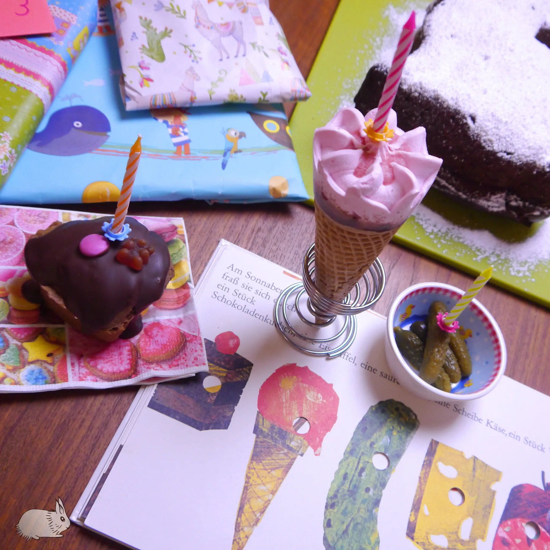 Detailansicht einer illustrierten Seite aus dem Raupe Nimmersatt Buch, die viele Leckereien zeigt.