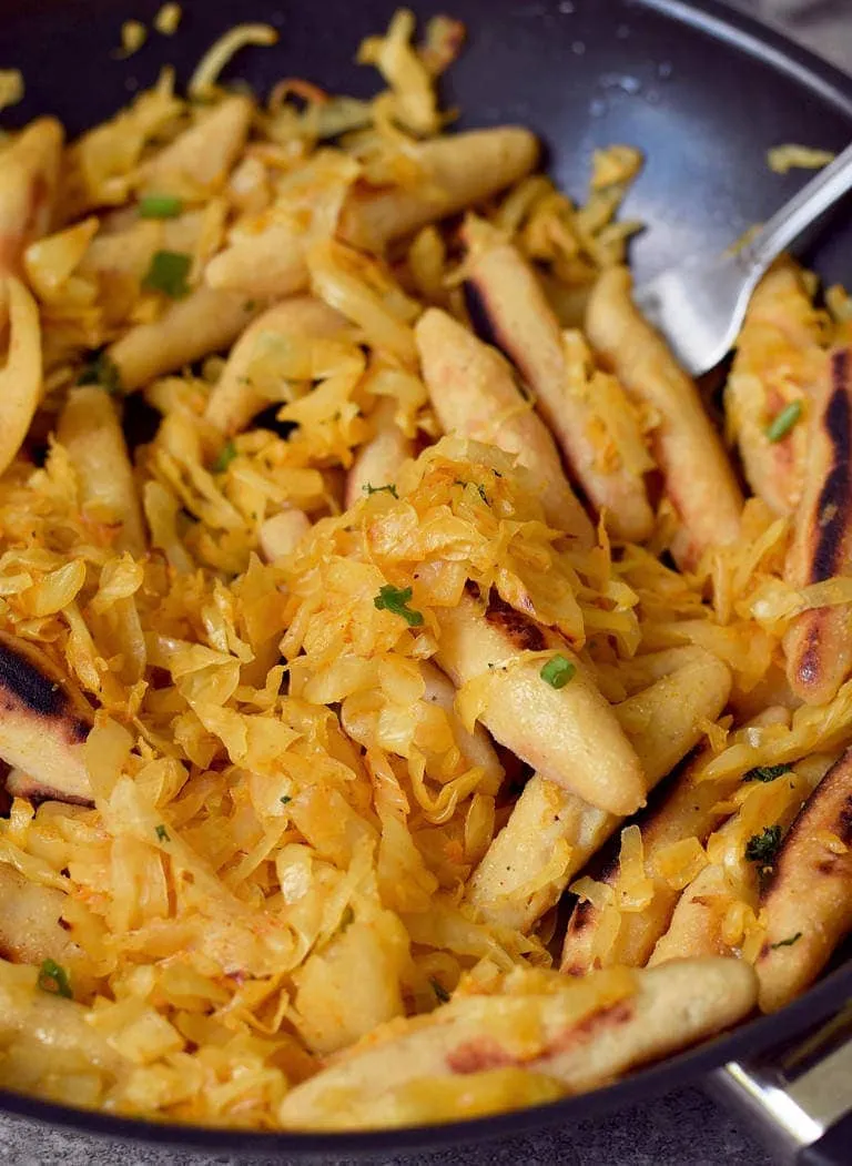 Detailansicht: goldbraun gebratenes Sauerkraut und Schupfnudeln, eine klassische Beilage