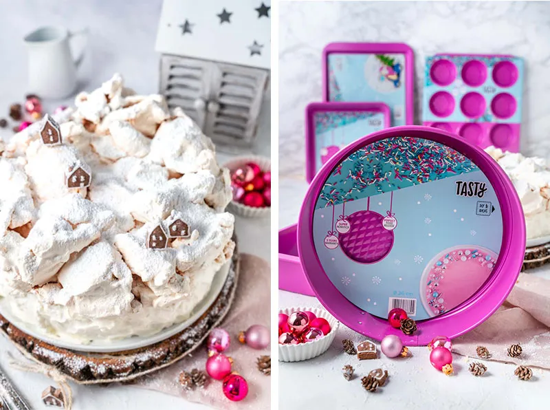 Detailaufnahme der dekorierten Käse-Sahne-Torte mit Lebkuchenhäusern und Puderzucker.