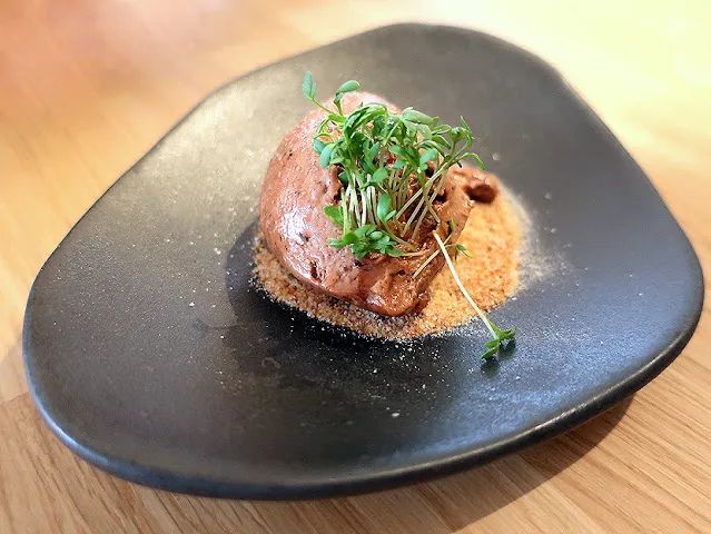 Detailaufnahme des Oliveneises, serviert mit frischem Brot, ein einzigartiger Bestandteil des veganen Menüs der Hummelbude Essen.
