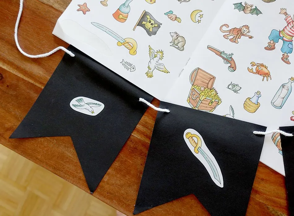 Detailaufnahme einer DIY Piraten-Wimpelkette mit bunten Aufklebern als festliche Dekoration.