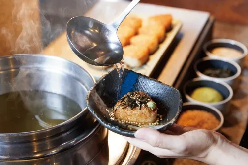 Detailaufnahme von Osakaer Spezialität &quot;Niku-Sui&quot; und gegrillten Reisbällchen mit Dashi-Brühe im Hotel Agora Osaka Moriguchi