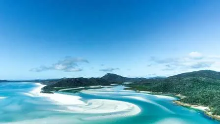 Die atemberaubende Luftaufnahme der Whitsunday Islands in Australien, mit weißen Sandbänken, üppig grünen Inseln und dem Great Barrier Reef.