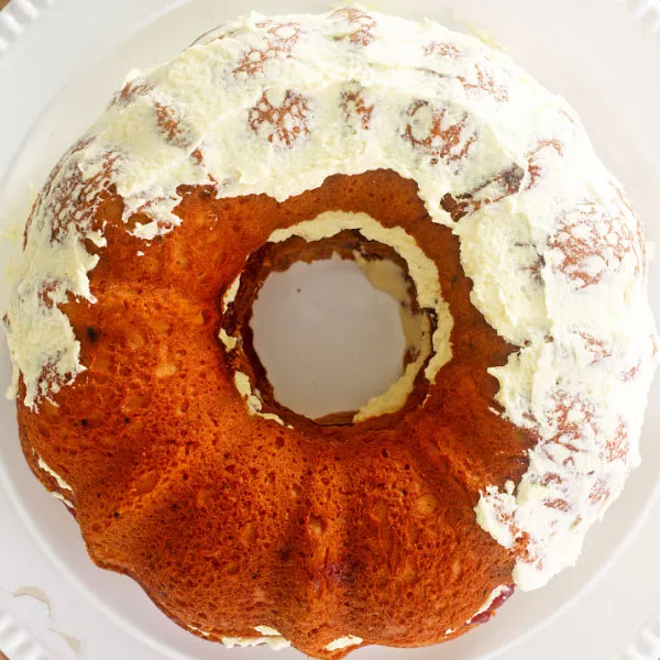 Die Außenseite des Kuchens mit Buttercreme bedecken und dann mit dem Krokant bestreuen