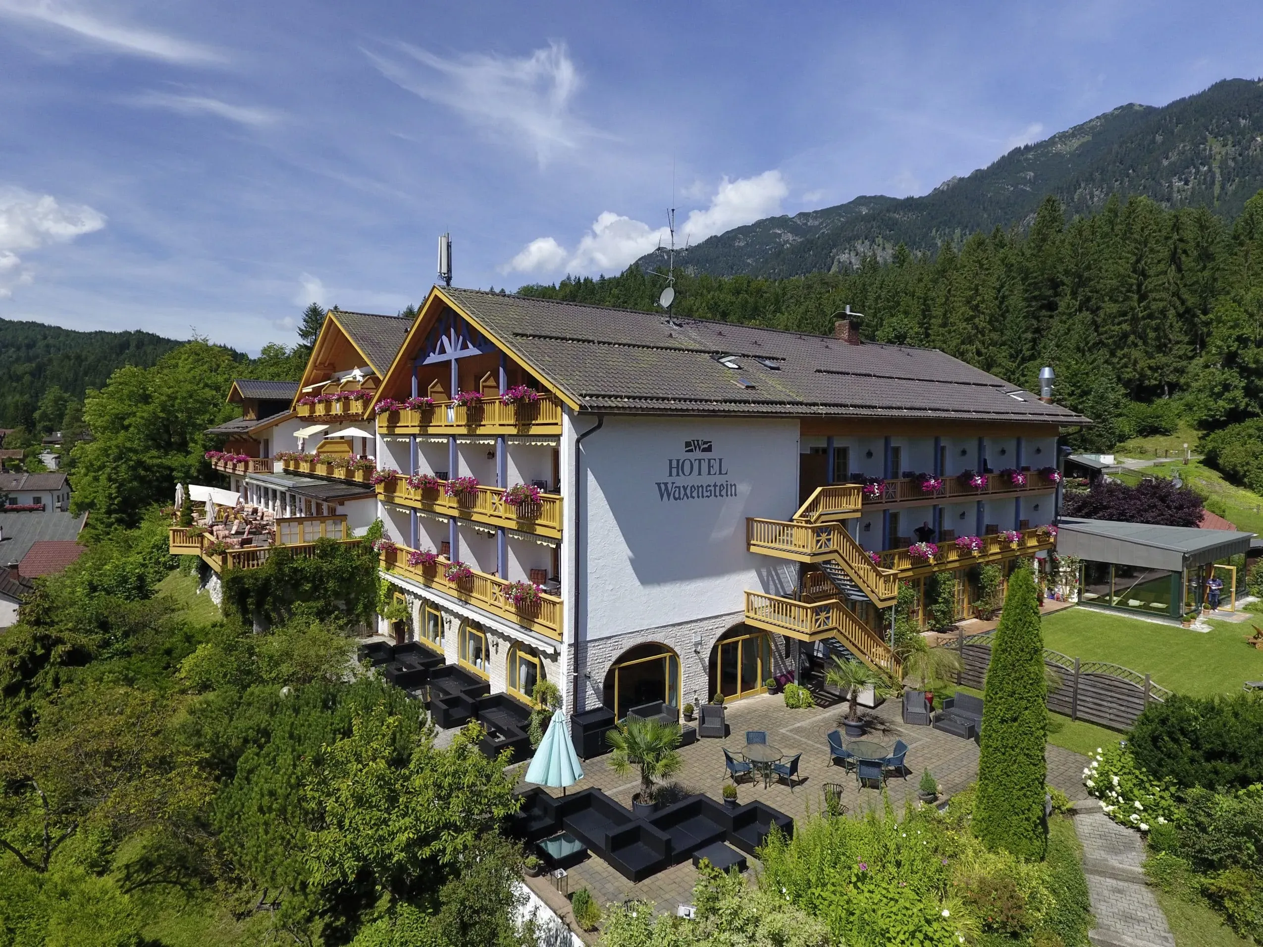 Die beeindruckende Außenansicht des Romantik Alpenhotel Waxenstein in Grainau, eingebettet in die majestätische Berglandschaft und ideal als Hotel mit Hund.