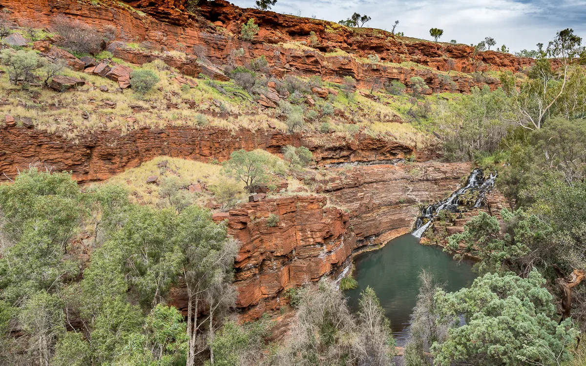 Die beeindruckende Dales Gorge mit Fortescue Falls im Karijini Nationalpark, Westaustralien, ein ideales Ziel für Wanderungen im Mai trotz intensiver Sonne.