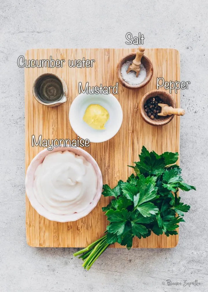 Die Dressingzutaten für veganen Nudelsalat: Mayonnaise, gelber Senf, Gurkenwasser, Salz und Pfeffer, die die Basis für den cremigen und würzigen Geschmack bilden.