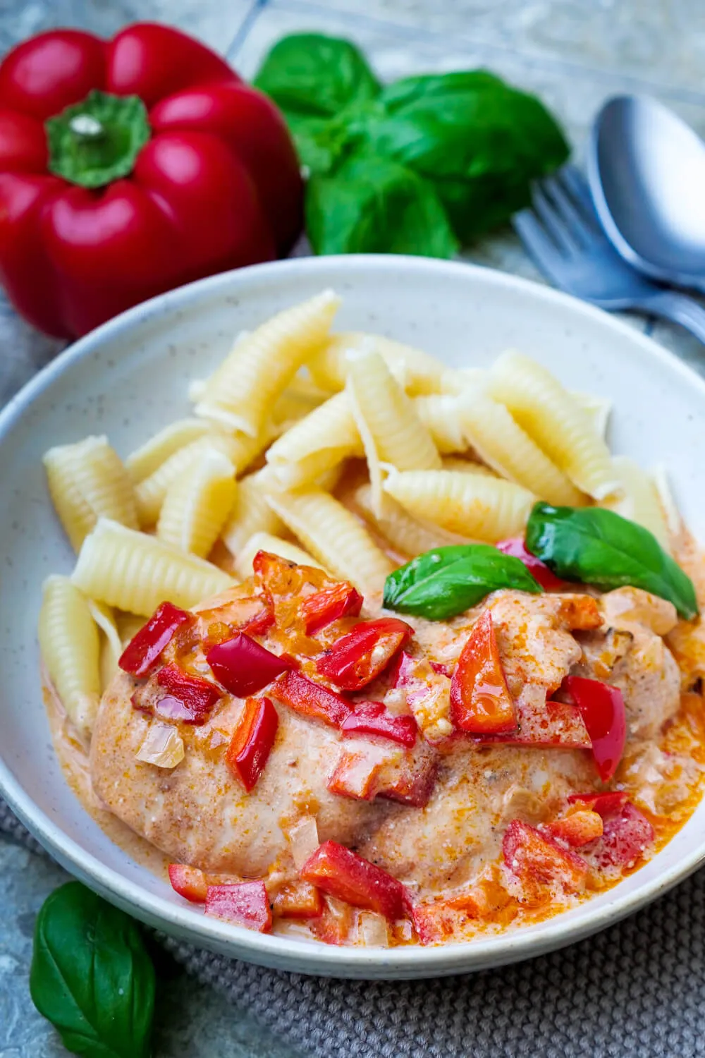 Die fertige Paprika-Sahne-Sauce wird über Hähnchen und Paprika gegeben