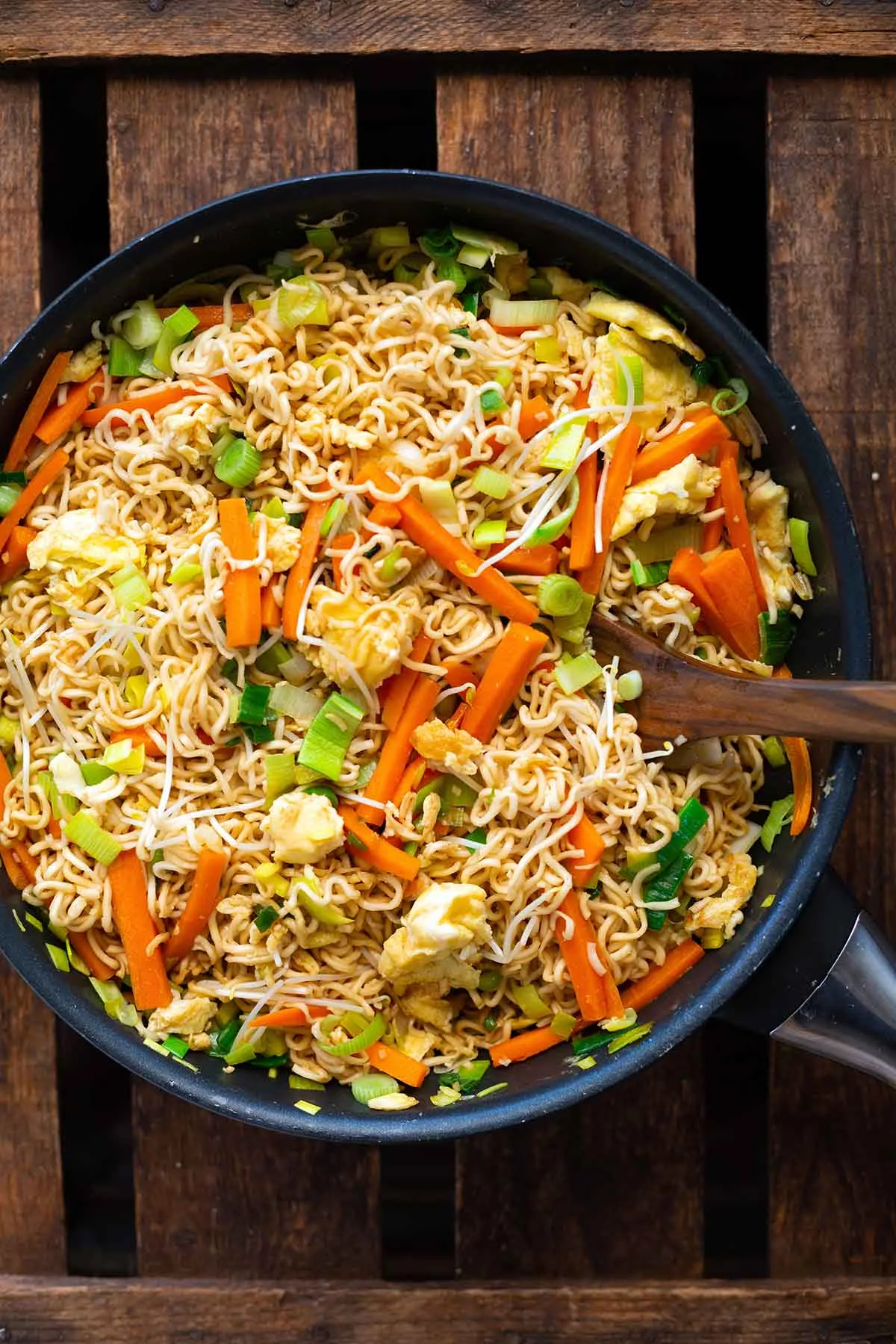 Die fertigen chinesischen gebratenen Nudeln mit viel Gemüse und Ei sind perfekt gemischt und bereit zum Servieren direkt aus der großen Pfanne.