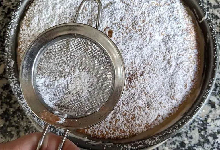 Die frisch gekühlte Torte wird mit Puderzucker bestreut und zum Servieren vorbereitet