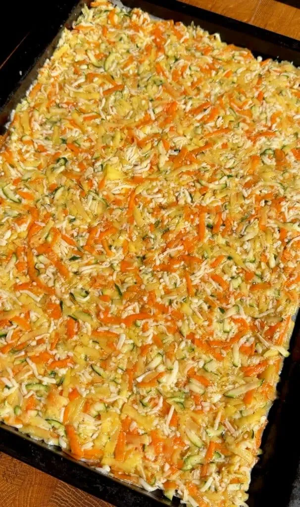 Die Low Carb Gemüsemischung wird gleichmäßig auf einem mit Backpapier ausgelegten Backblech verteilt