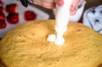 Die mit Sahne bedeckte Oberfläche des Kuchens, kunstvoll gespritzt