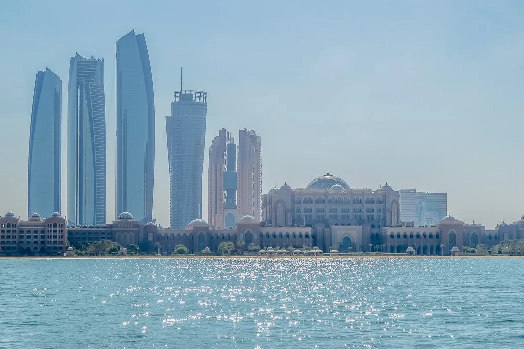 Die moderne Skyline von Abu Dhabi, vom Wasser aus fotografiert, bei Sonnenuntergang