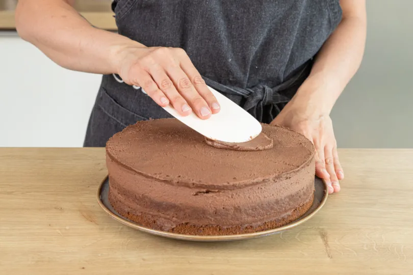 Die Schokosahnetorte wird rundherum eingestrichen