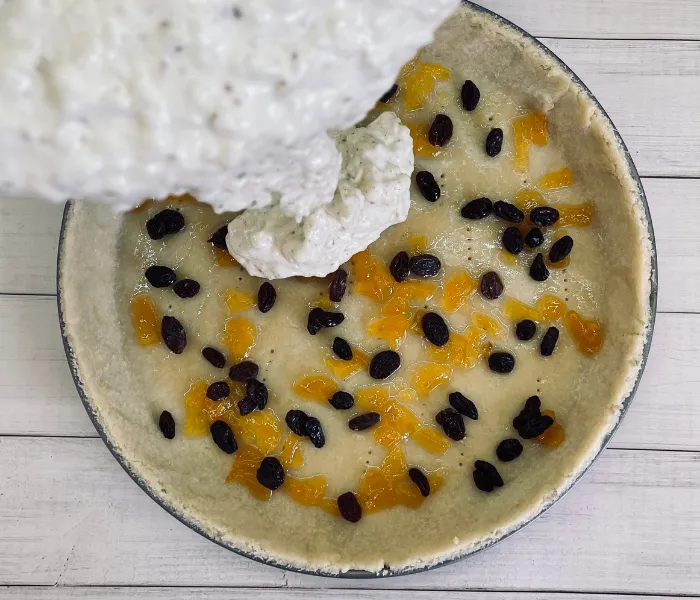 Die süße Milchreisfüllung wird in den vorbereiteten Osterkuchen-Teig gegeben