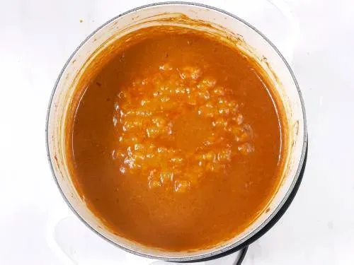 Die Tikka Masala Sauce köchelt, bevor das gegrillte Hähnchen hinzugefügt wird