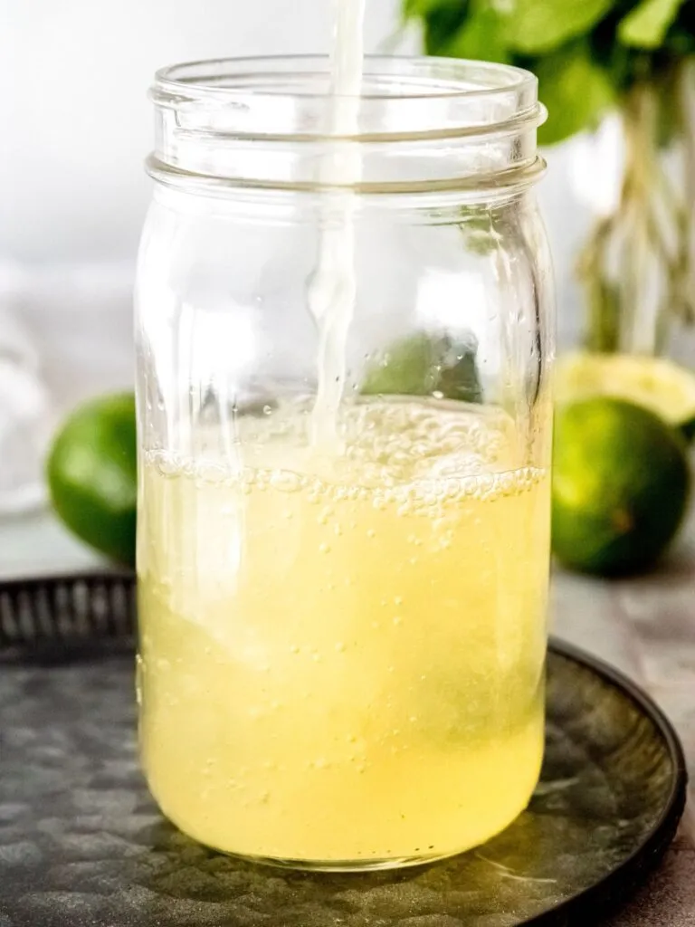 Die zubereitete Cool Lime Refresher Basis wird zum Abkühlen in ein Glasgefäß gefüllt.