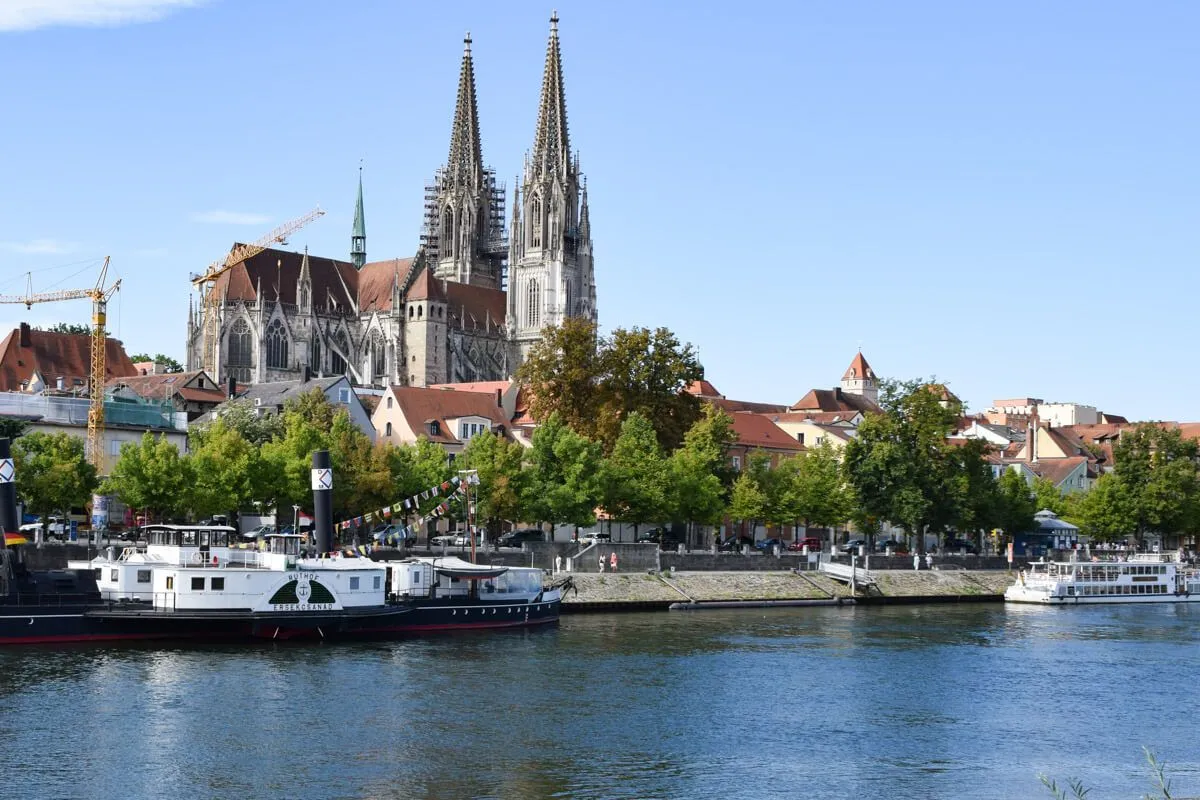 Domblick am Fluss: Die Donau fließt durch Regensburg mit dem imposanten Dom im Hintergrund