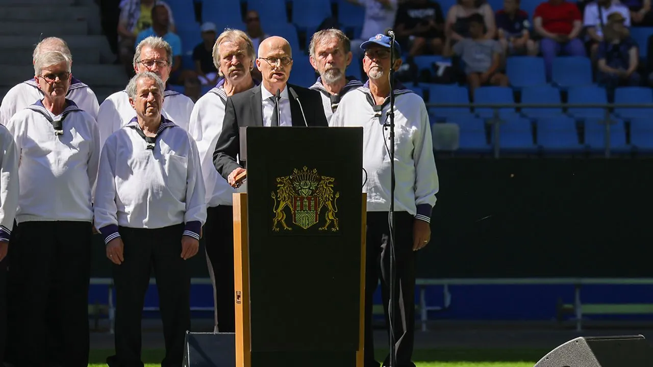 Dr. Peter Tschentscher am Rednerpult bei der Uwe Seeler Trauerfeier, flankiert vom Hamburger Seemannschor