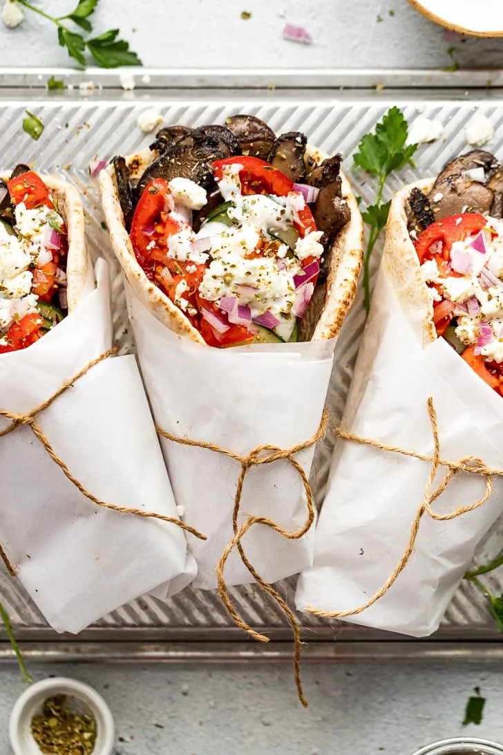 Drei Gyros in Papier gewickelt auf einem Metalltablett, mit Bindfaden