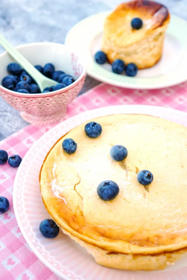 Drei Stücke Low Carb Käsekuchen auf einem Teller, elegant mit blauen Heidelbeeren garniert, ideal für die Kaffeetafel.