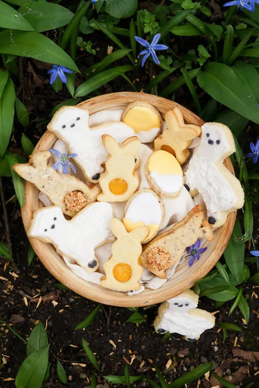 Drei verschiedene Osterkekse: Haselnuss-Häschen, Zitronen-Häschen und Osterlamm-Zuckerkekse kunstvoll arrangiert