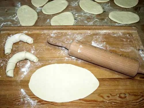 Dünn ausgerollte ovale Teigstücke für die Hörnchen Brötchen Zubereitung