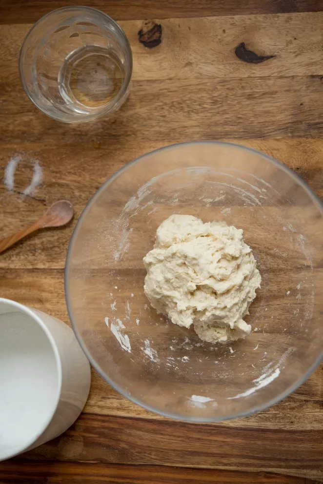 Dünn ausgerollter Flammkuchenteig auf Backpapier, bereit zum Belegen