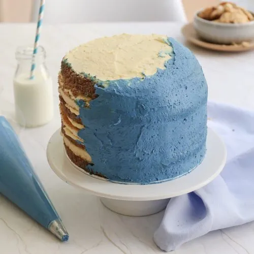 Dünne Krümelschicht aus Buttercreme auftragen, um den Krümelmonster Geburtstagskuchen zu stabilisieren