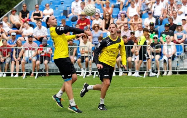Dynamisches Faustballspiel mit Spielern in Aktion und dem Faustball in der Luft