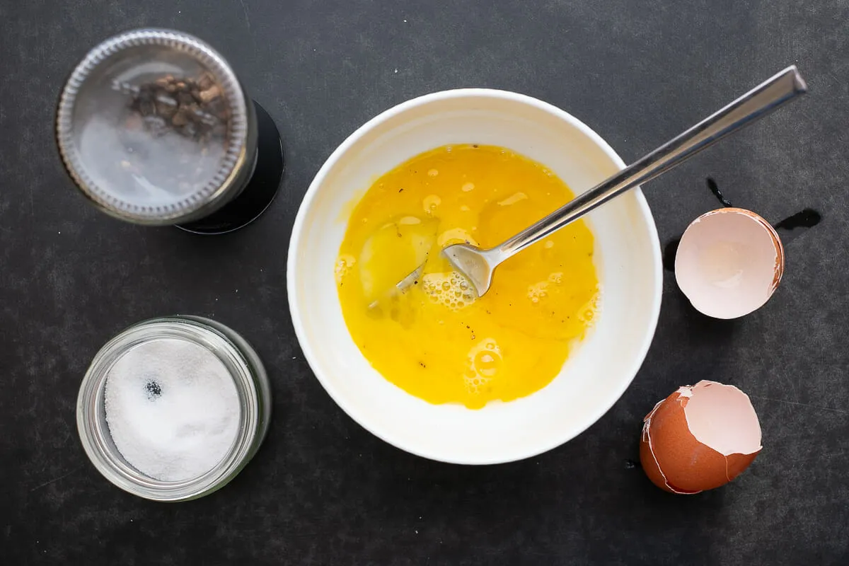 Eier werden gewürzt und verquirlt.
