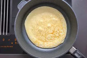 Eierkuchen mit einem Pfannenwender wenden