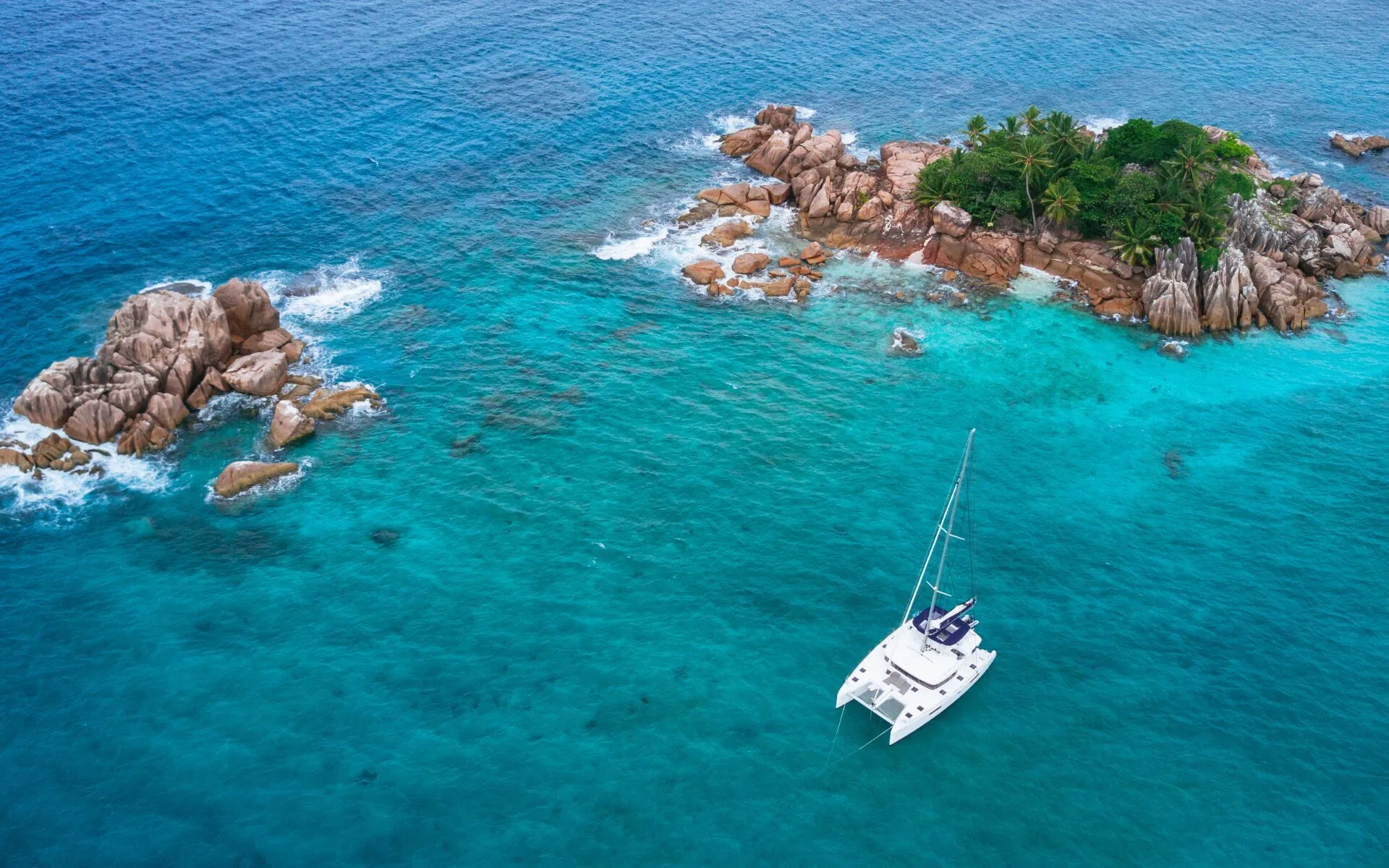 Ein abgelegener Strand auf den Seychellen mit Granitfelsen und Palmen