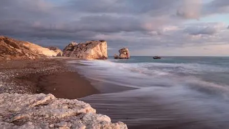 Ein abgelegener Strandabschnitt auf Zypern, mit felsiger Küste, klarem blauen Mittelmeer und einem sonnigen Himmel.