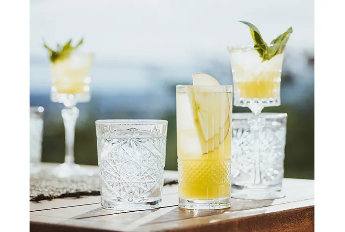 Ein Amouro Sour Cocktail in einem Glas, garniert mit einem Basilikumblatt