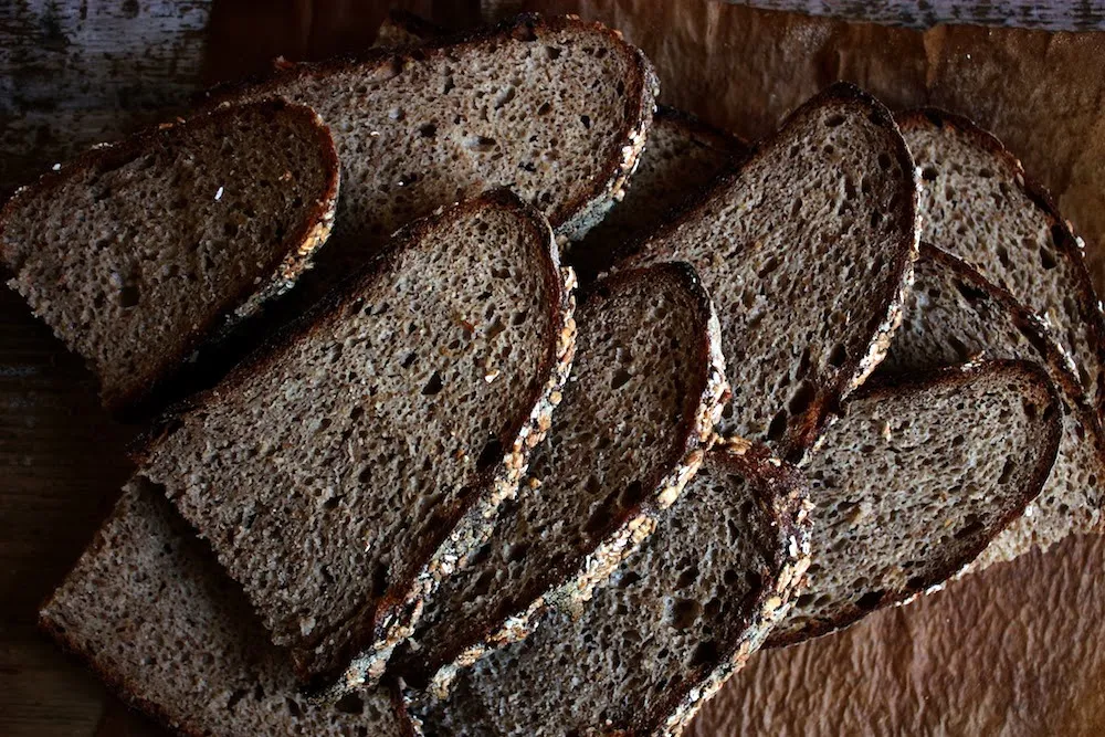 Ein angeschnittenes Roggen-Vollkornbrot, das die feine Krume und die Roggenkörner zeigt