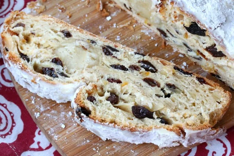Ein Anschnitt des gebackenen Stollen zeigt die saftige Füllung aus Früchten, Nüssen und Marzipan, bestäubt mit Puderzucker.
