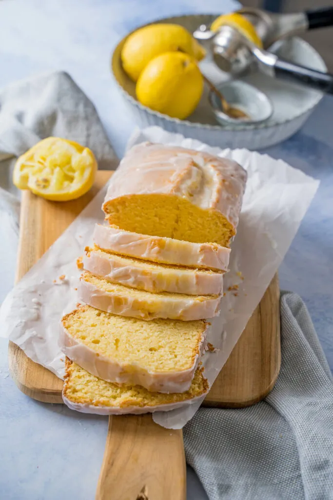 Ein Anschnitt des saftigen Zitronenkuchens, der die feine Krume und den feuchten Teig zeigt, bedeckt mit einer glasierten Zitronenoberfläche.