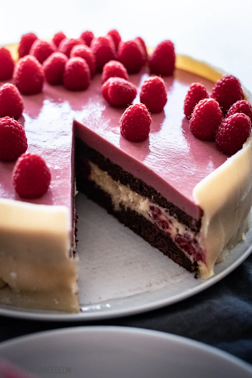 Ein Ansicht eines fertigen Lagkage, des beliebten dänischen Geburtstagskuchens, mit Schokolade, Vanille und frischen Himbeeren