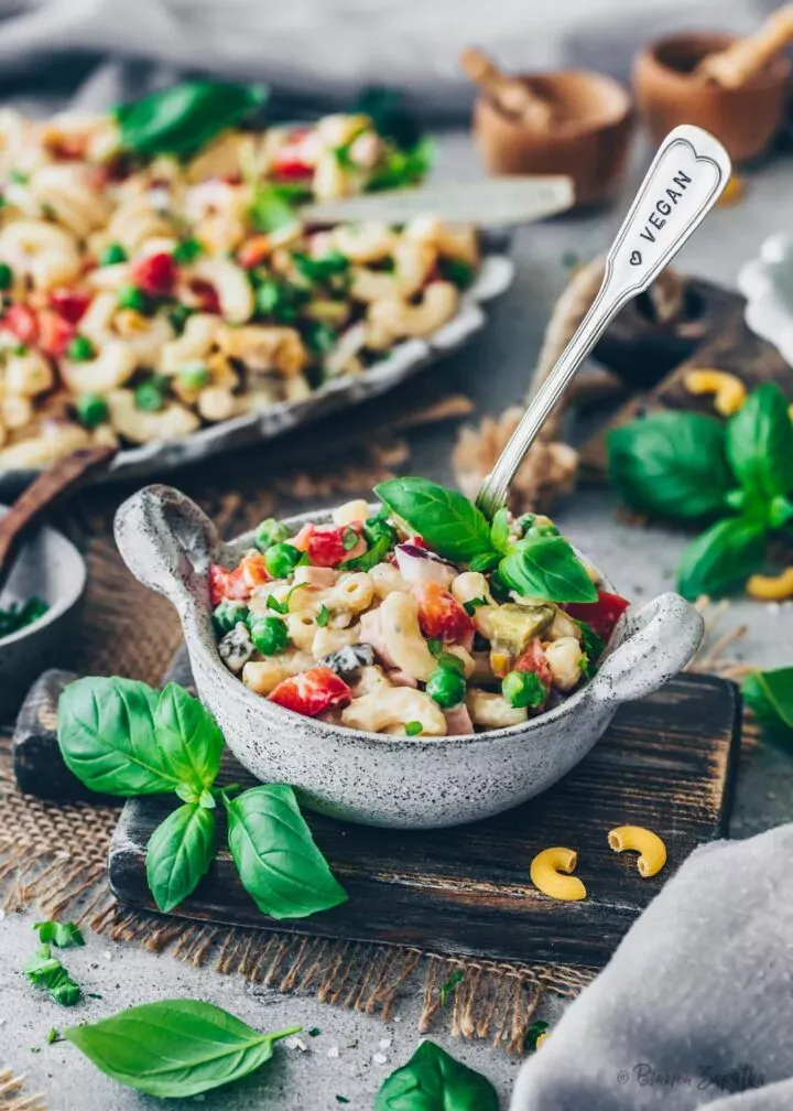 Ein appetitlich angerichteter Teller mit veganem Nudelsalat, der die fertige Mahlzeit mit ihrer cremigen Textur und den frischen Gemüsesorten zeigt.