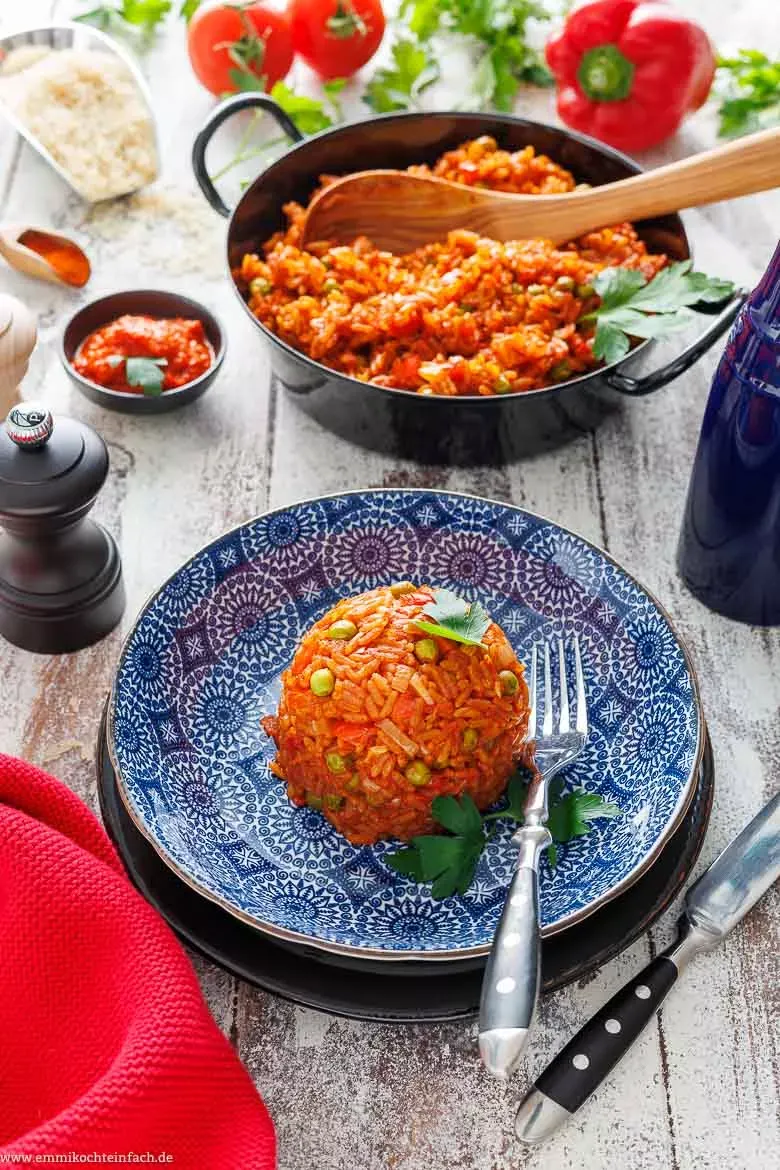 Ein aromatischer Djuvec Reis, fertig serviert in einer Schale, verziert mit frischer Petersilie, bereit zum Genuss.