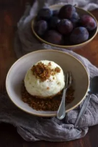 Ein Bild von Zwetschgenknödeln mit Hefeteig in einem Teller, bestreut mit Zucker
