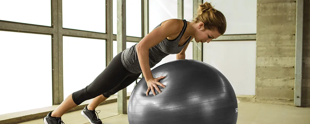 Ein blauer Stabilitätsball im Fitnessstudio vor Gewichten