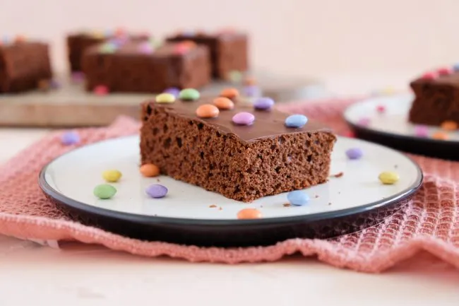 Ein Blech mit saftigem Schokoladenkuchen, verziert mit bunten Smarties
