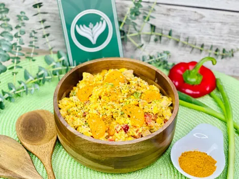 Ein bunter Curry-Reissalat mit Mandarinen und frischen Kräutern in einer Schale