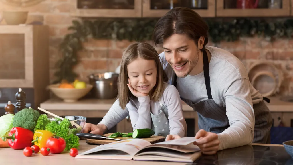 Ein cremefarbenes SMEG Kochzentrum mit passender Dunstabzugshaube in einem eleganten Küchenambiente.
