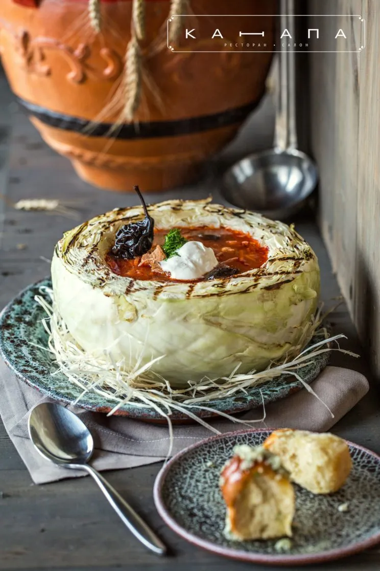 Ein dampfender Teller Borschtsch mit frischer Sauerrahm und Dill, das ikonische ukrainische Gericht.