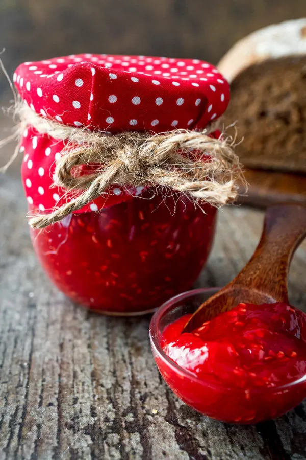 Ein Detailbild von selbstgemachter Himbeermarmelade in einem Glas, perfekt für den Start in den Tag.