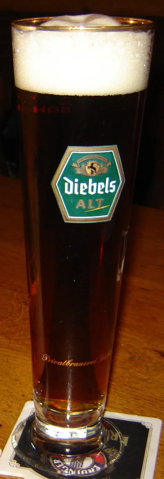 Ein Diebels Altbier, typischerweise in einem traditionellen Glas in einer gemütlichen Kneipe genossen.