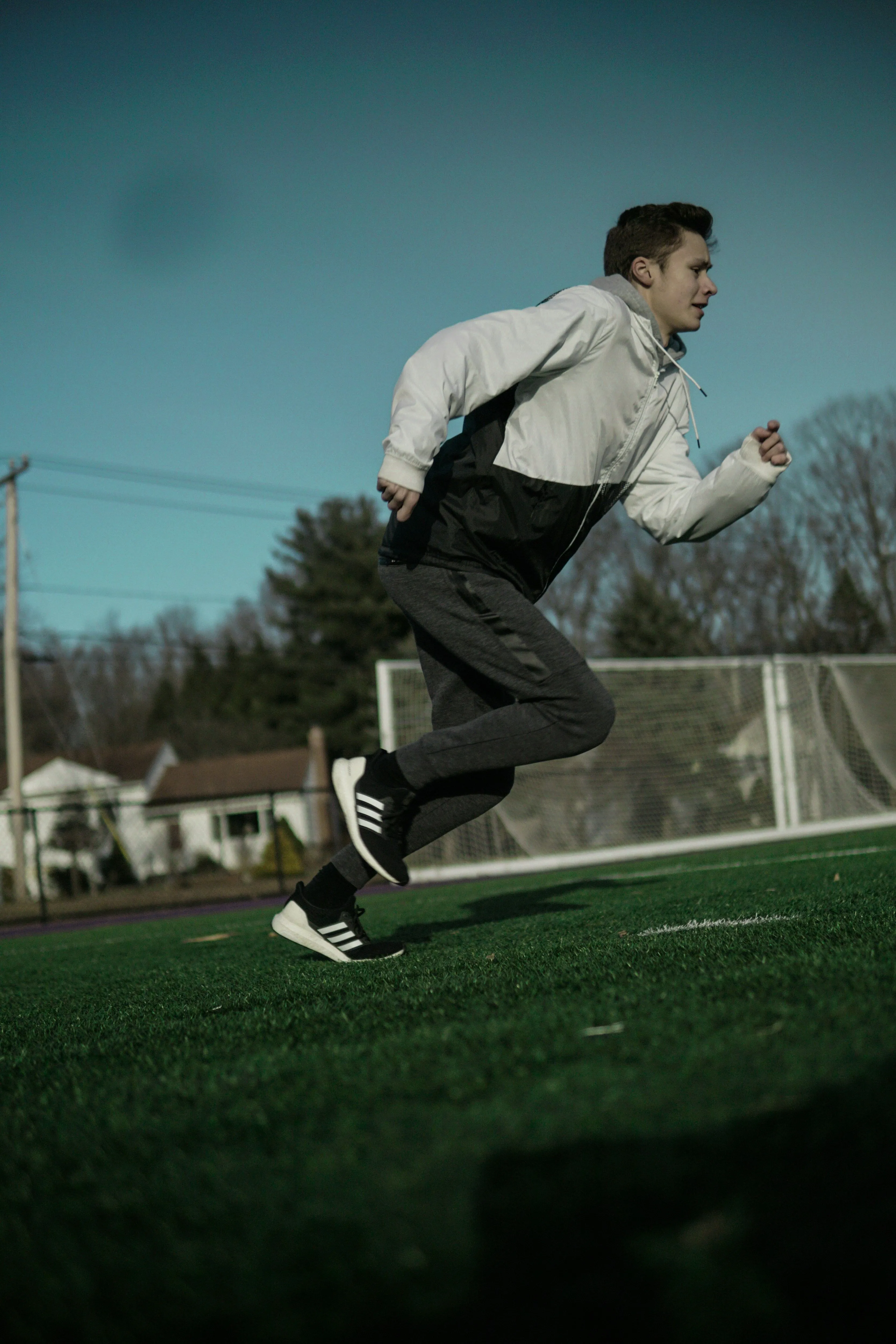 Ein energischer Mann beim Laufen über eine Wiese, symbolisiert intensives Training wie HIIT zur effektiven Bauchfettverbrennung.